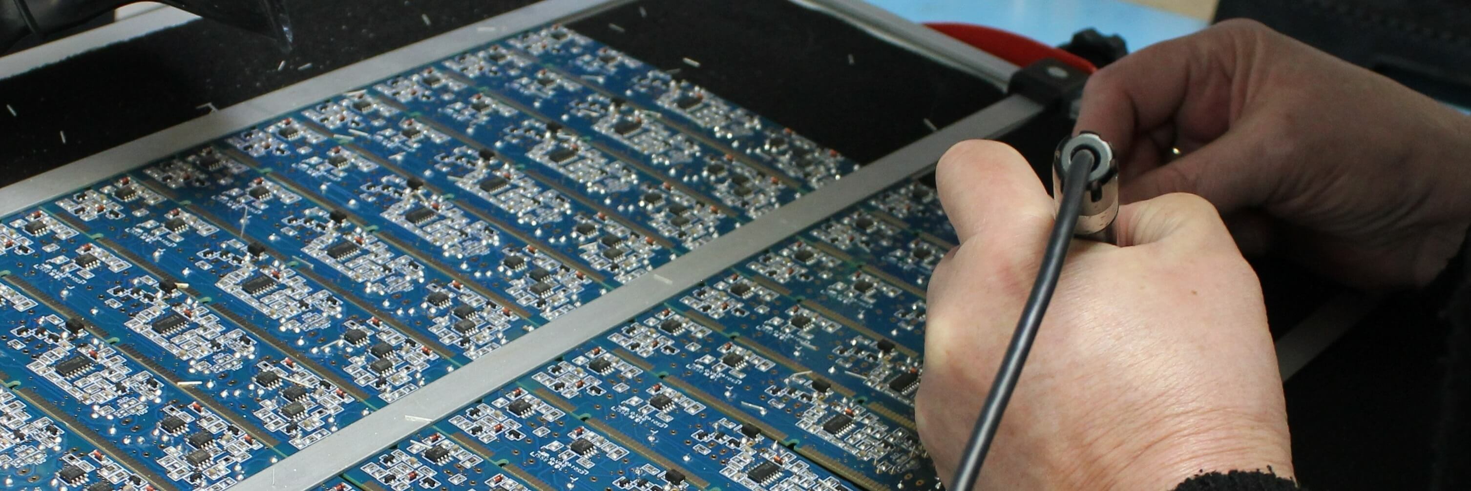 An image of an operator soldering using a soldering iron